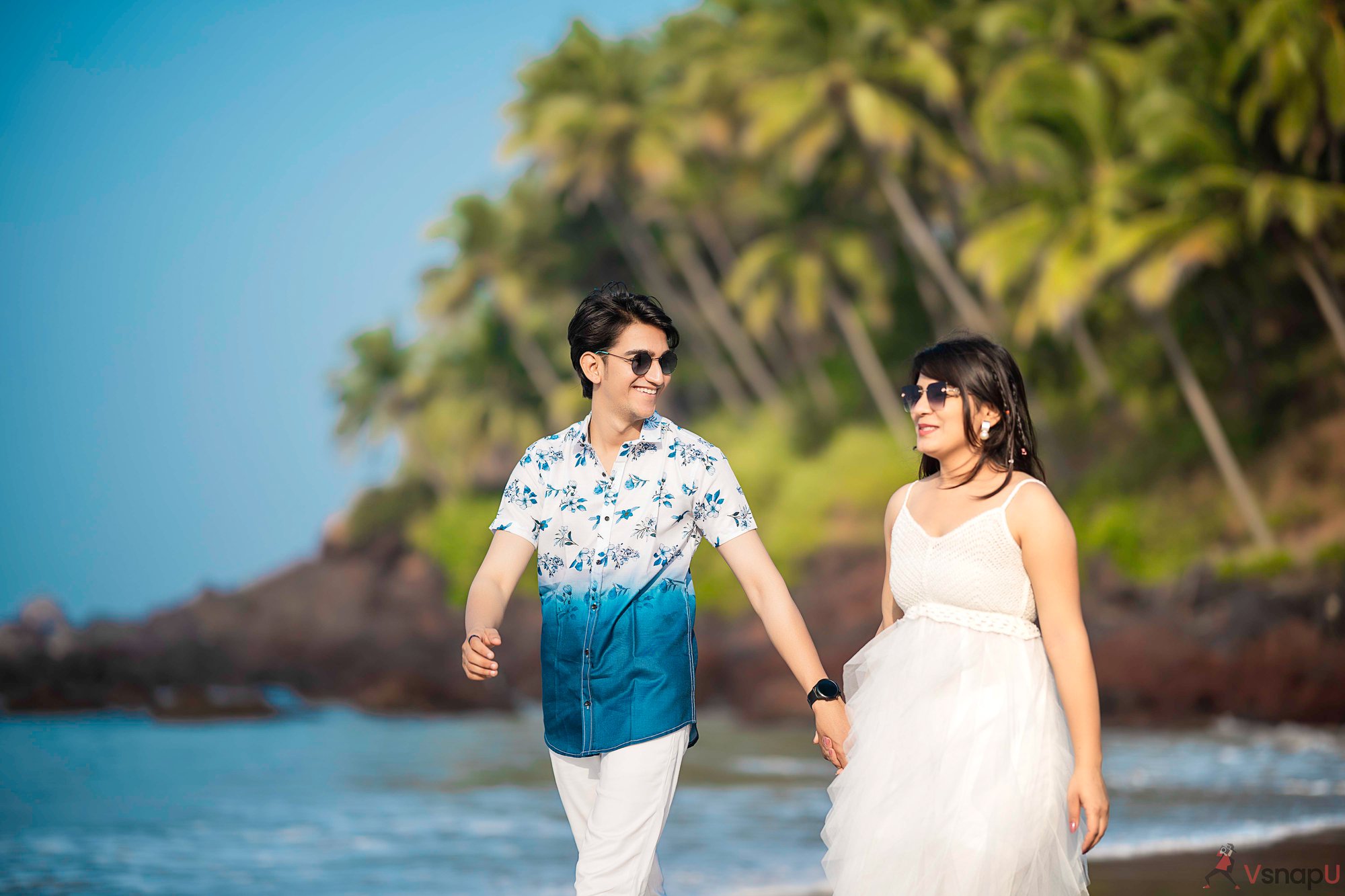 Romantic beach moment for couple photoshoot with greenery